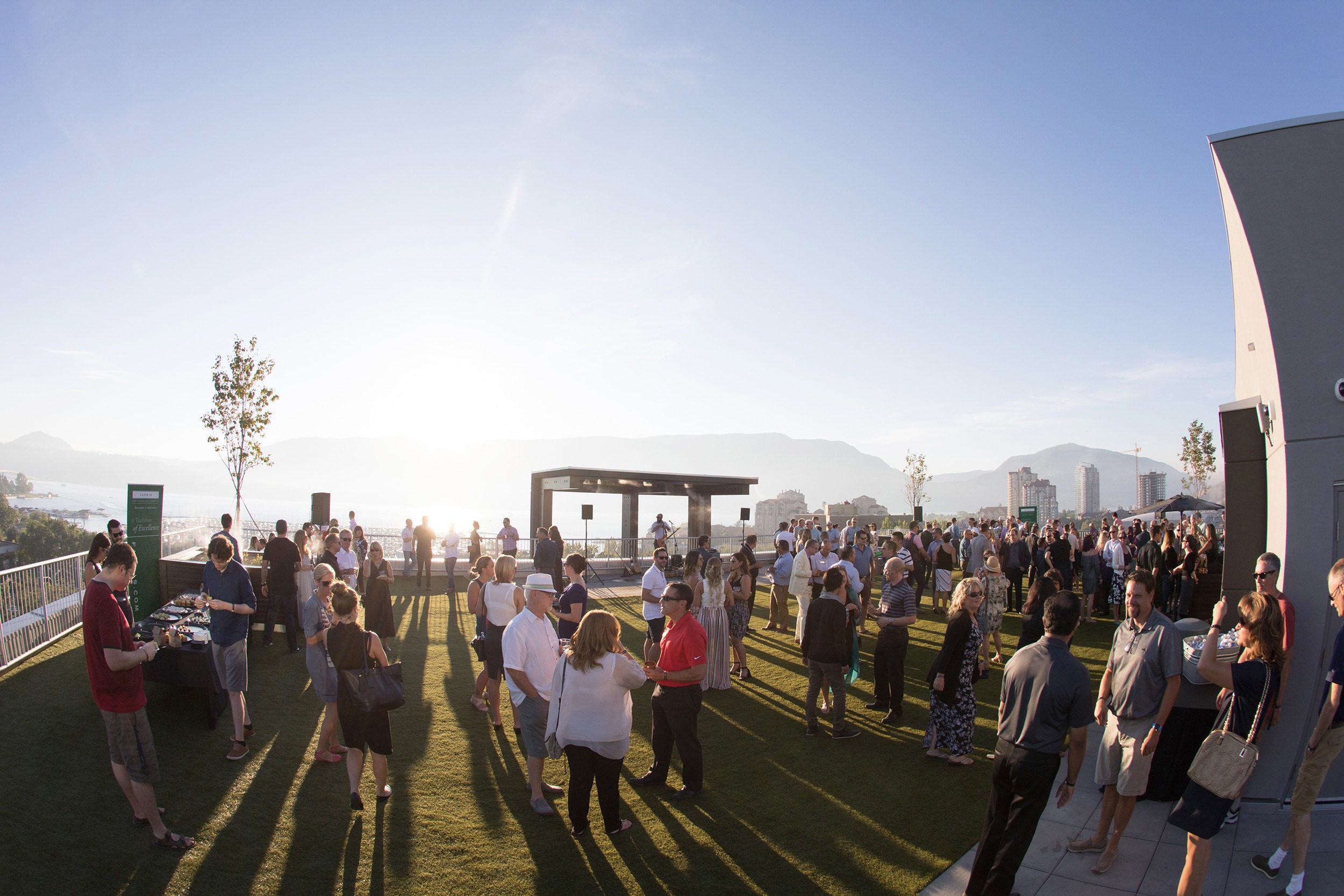 Rooftop event with large crowd, DJ, live music, on the rooftop of the Innovation Centre on a sunny day in Downtown Kelowna